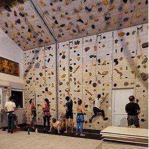 Crianças escalando o muro com instrutores