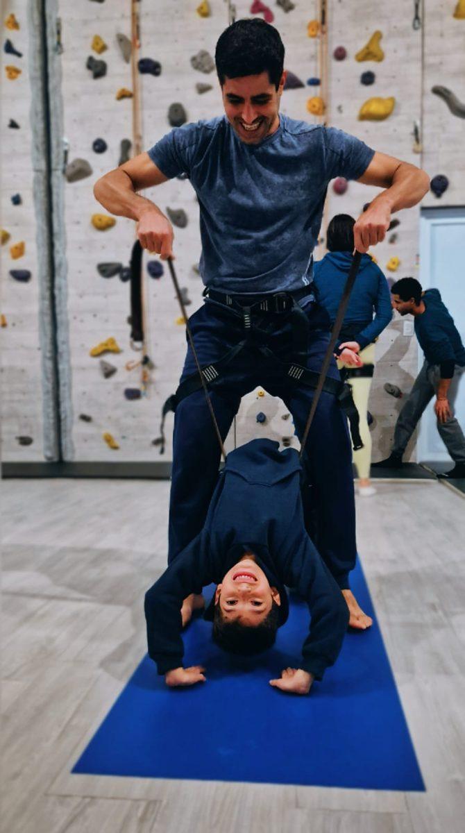 Menino fazendo acrobacia com o professor