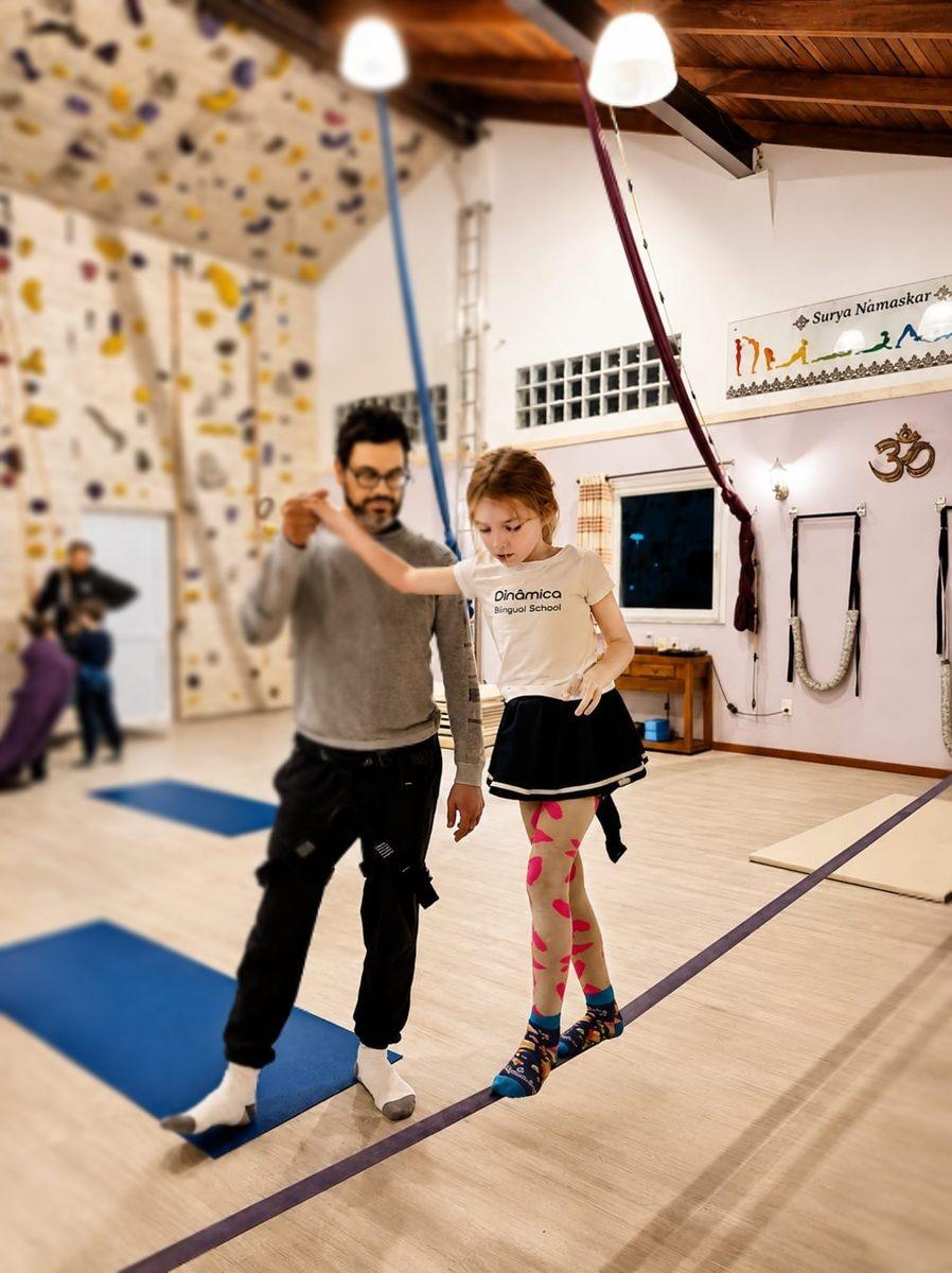 Menina no slackline com o professor
